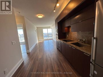 Toronto (Willowdale East) condo for rent - A kitchen with dark wood floors and a refrigerator on the right.