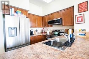 Toronto (Woburn) condo for rent - A kitchen with a refrigerator, microwave, and oven.
