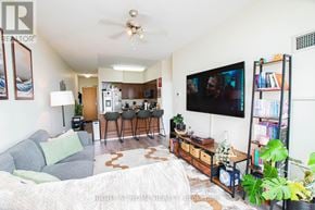 Toronto (Woburn) condo for rent - A living room with a grey couch and a television on the wall.