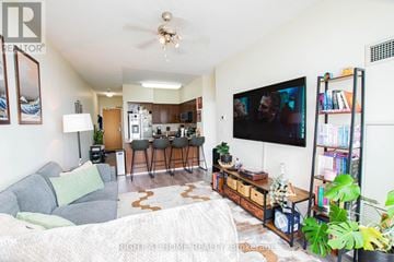 Toronto (Woburn) condo for rent - A living room with a grey couch and a television on the wall.
