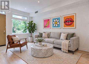Toronto (High Park North) apartment for rent - A living room with a grey couch, a brown chair, and a coffee table with a plant on it.