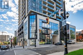 Hamilton (Central) condo for rent - A street view of a city with a large building in the background and a traffic light on the right.