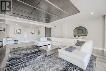 Hamilton (Central) condo for rent - A modern living room with a white sofa and a black and white rug.