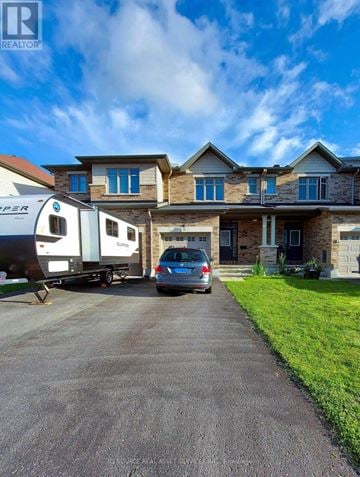 Ottawa townhouse for rent - A house with a car and a camper van parked in front.