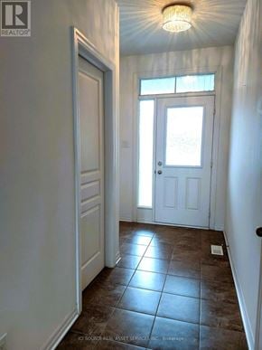 Ottawa townhouse for rent - A hallway with a brown tile floor and white walls.