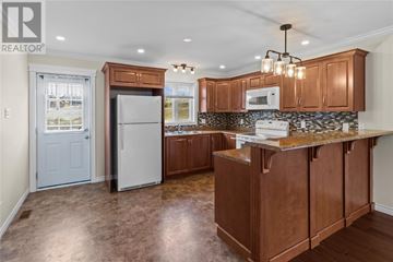 St. John's multi-family for rent - A kitchen with brown cabinets and a white fridge.