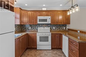 St. John's multi-family for rent - A kitchen with brown cabinets and a white refrigerator.