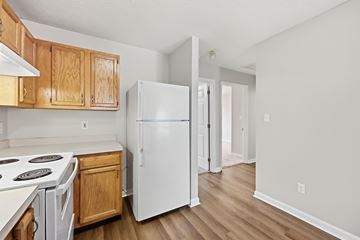 Lexington apartment for rent - A kitchen with a white refrigerator and wooden cabinets.