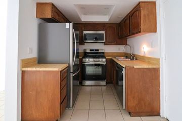 Oceano apartment for rent - A kitchen with wooden cabinets and a white refrigerator.
