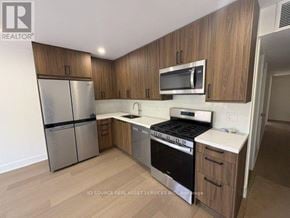 Toronto (University) apartment for rent - A kitchen with wooden cabinets and stainless steel appliances.