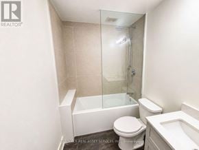 Toronto (University) apartment for rent - A white toilet sits next to a white bathtub in a bathroom.