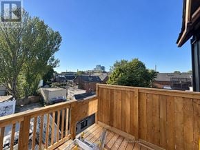 Toronto (University) apartment for rent - A wooden deck with a bench overlooks a residential area.