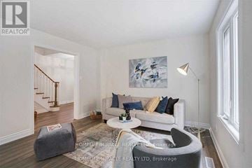 Mississauga (Meadowvale) apartment for rent - A living room with a couch, a chair, a rug, and a painting on the wall.