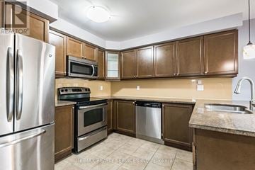 Milton (Ha Harrison) townhouse for rent - A kitchen with brown cabinets and a stainless steel refrigerator.