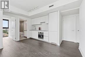Toronto (Thorncliffe Park) condo for rent - A spacious kitchen with white cabinets and a wooden floor.