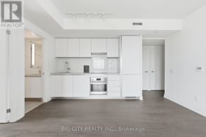 Toronto (Thorncliffe Park) condo for rent - A white kitchen with a refrigerator, sink, and cabinets.