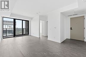 Toronto (Thorncliffe Park) condo for rent - A spacious room with a sliding glass door and wooden flooring.