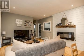 Bradford West Gwillimbury (Bradford) fourplex for rent - A living room with a grey couch and a fireplace.