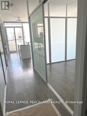 Toronto (Kensington-Chinatown) condo for rent - A room with glass walls and wooden floors.