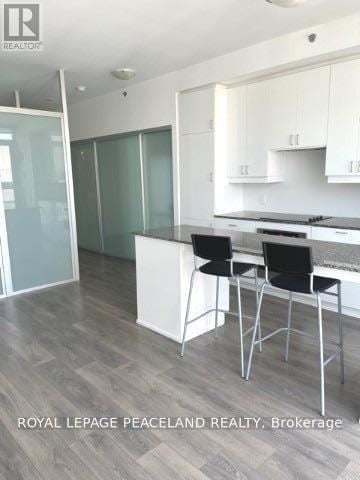 Toronto (Kensington-Chinatown) condo for rent - A modern kitchen with white cabinets and a glass backsplash.