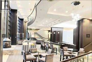 Toronto (Willowdale East) condo for rent - A modern living room with a glass table and chairs.