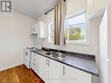 Halton Hills (Georgetown) multi-family for rent - A kitchen with white cabinets and a black countertop.