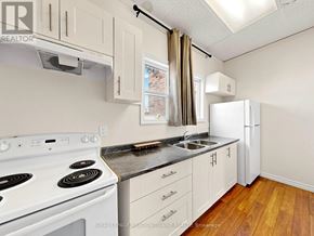 Halton Hills (Georgetown) multi-family for rent - A kitchen with white appliances and wooden floors.