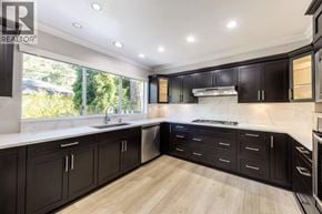 Vancouver apartment for rent - A modern kitchen with dark wood cabinets and a white countertop.