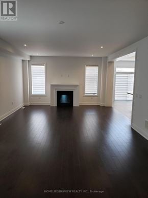 Oakville (Go Glenorchy) apartment for rent - A spacious room with wooden floors and white walls.