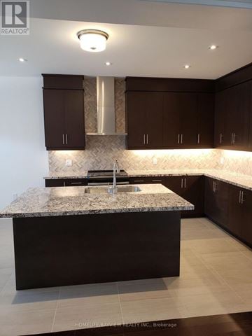 Oakville (Go Glenorchy) apartment for rent - A kitchen with brown cabinets and a marble countertop.