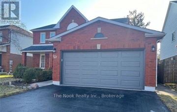 Clarington (Courtice) apartment for rent - A red brick house with a grey garage door in front.