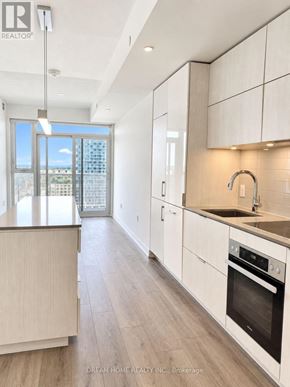 Toronto (Waterfront Communities) condo for rent - A modern kitchen with white cabinets and a wooden island.