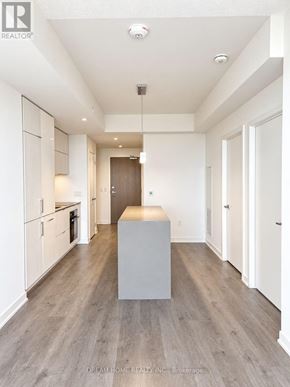 Toronto (Waterfront Communities) condo for rent - A modern kitchen with white cabinets and a wooden floor.