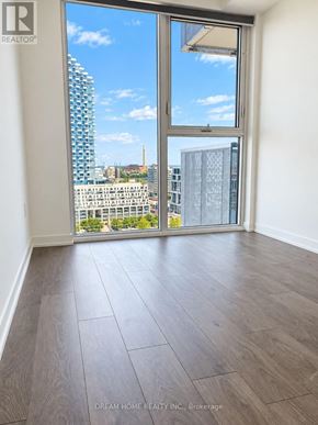 Toronto (Waterfront Communities) condo for rent - A room with a large window overlooking a cityscape.