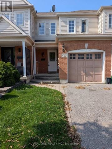 Whitby (Taunton North) townhouse for rent - A house with a garage door and a driveway.