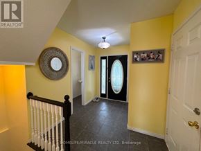 Orangeville apartment for rent - A hallway with a white door, a mirror, and a framed picture on the wall.
