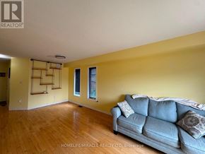 Orangeville apartment for rent - A living room with a grey couch and wooden floors.
