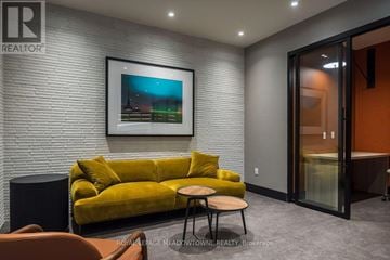 Milton (Tm Timberlea) condo for rent - A living room with a yellow couch and a painting on the wall.