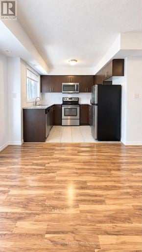 Oakville (Ro River Oaks) townhouse for rent - A kitchen with a black fridge and wooden floors.