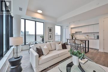 Toronto (Thorncliffe Park) condo for rent - A modern living room with a white sofa and a glass table.