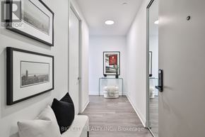 Toronto (Thorncliffe Park) condo for rent - A hallway with a white couch and pictures on the wall.