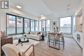 Toronto (Thorncliffe Park) condo for rent - A well-lit, modern living room with a dining area and kitchen in the background.