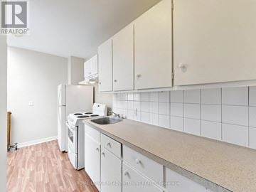 Halton Hills (Georgetown) multi-family for rent - A kitchen with white cabinets and a white fridge.