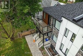 Ottawa apartment for rent - A modern house with a balcony and a tree in the front yard.