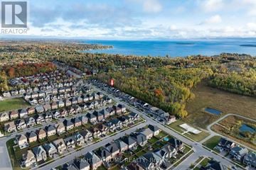 Innisfil apartment for rent - A bird's eye view of a residential neighborhood with houses, roads, and a body of water in the distance.