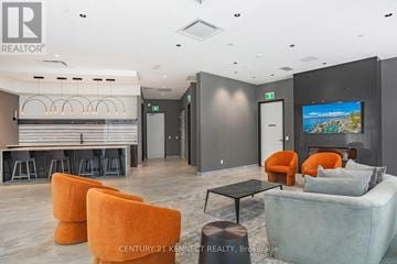 Richmond Hill condo for rent - A modern living room with orange chairs and a bar area.