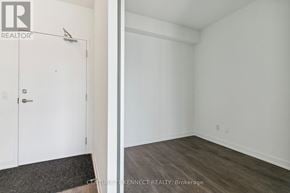 Richmond Hill condo for rent - A white room with a wooden floor and a white door.