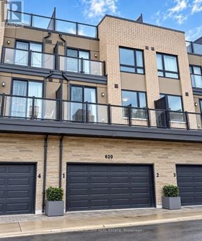 Toronto (West Humber-Clairville) townhouse for rent - A building with the number 620 on it has three garage doors.