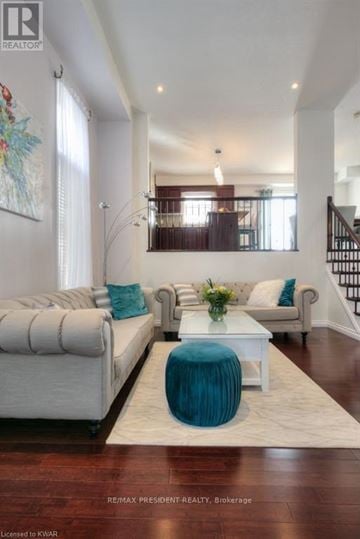 Kitchener apartment for rent - A living room with a white couch and a blue ottoman.