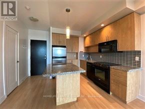 Toronto (North St. James Town) condo for rent - A kitchen with wooden cabinets and black appliances.